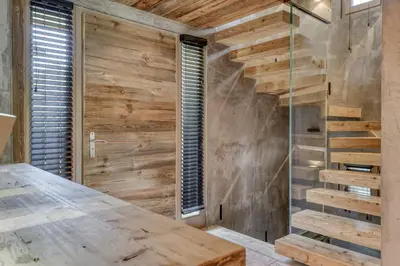 a wooden staircase in a room with a wooden wall at Chalet de luxe proche du village de Megève in Megève