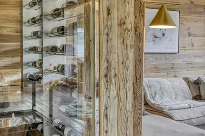 a glass display case in a room with a couch at Chalet de luxe proche du village de Megève in Megève