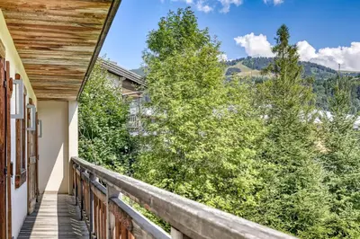 a balcony with a view of trees and mountains at Chalet de luxe proche du village de Megève in Megève