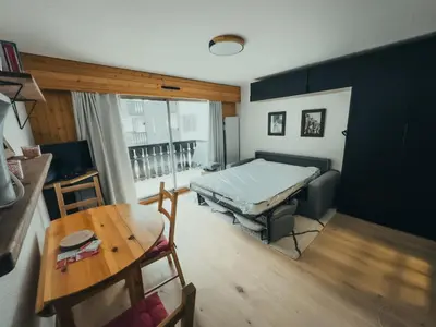 a living room with a bed and a table at Le Montenvers - Central Studio & Private parking in Chamonix-Mont-Blanc