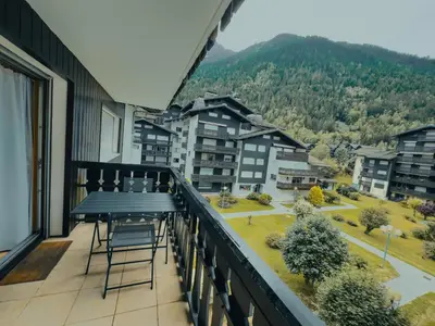 a balcony with a table and a view of a city at Le Montenvers - Central Studio & Private parking in Chamonix-Mont-Blanc