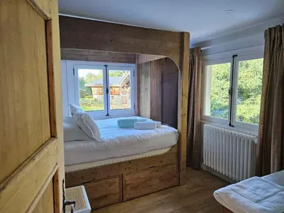 a bedroom with a large bed with a window at Rouge-Gorge, Appartement de charme, 3 chambres, Megève - Rochebrune in Megève