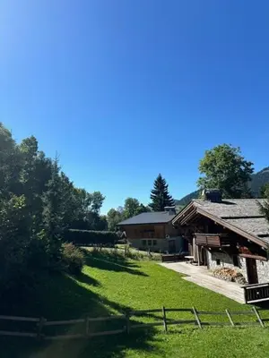 a barn with a fence next to a grass field at Rouge-Gorge, Appartement de charme, 3 chambres, Megève - Rochebrune in Megève