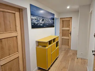 a yellow cabinet in a room with a painting on the wall at Rouge-Gorge, Appartement de charme, 3 chambres, Megève - Rochebrune in Megève