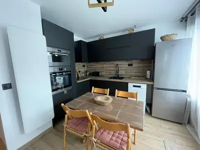 a kitchen with a table and chairs and a refrigerator at Studio Carroz d'Arâches 4 pers in Arâches-la-Frasse