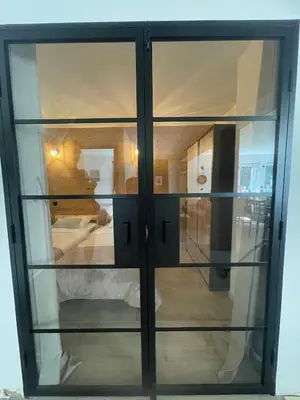 a glass cabinet with glass doors in a room at Cozy & modern apartment in Samoëns