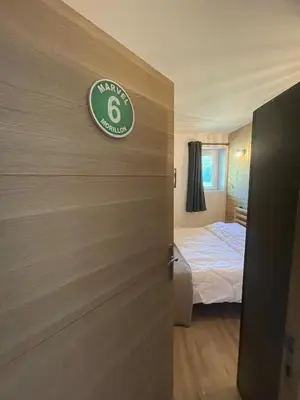 a room with a bed and a door with a sign on it at Cozy & modern apartment in Samoëns