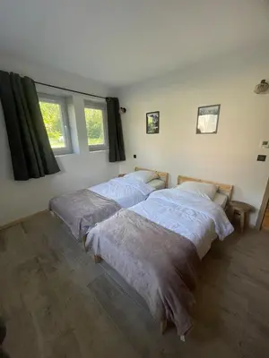 two beds in a room with two windows at Cozy & modern apartment in Samoëns