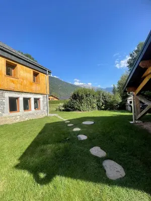 a garden with rocks in the grass next to a building at Cozy & modern apartment in Samoëns