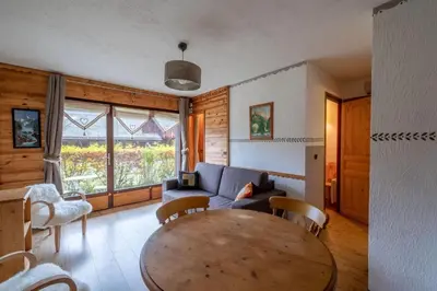 a living room with a table and a couch at Cosy alpine apartment with pool and stunning views in Saint-Gervais-les-Bains