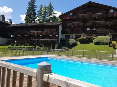 a swimming pool in front of a building at Cosy alpine apartment with pool and stunning views in Saint-Gervais-les-Bains