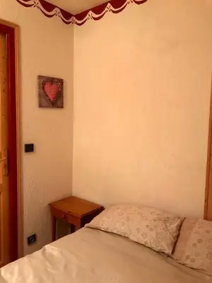 a bedroom with a bed and a small table at Cosy alpine apartment with pool and stunning views in Saint-Gervais-les-Bains