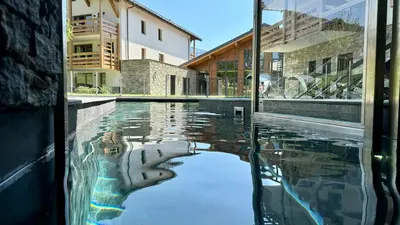 a swimming pool with a reflection of a building at Luxury Penthouse With Mont Blanc Views In Megève in Megève