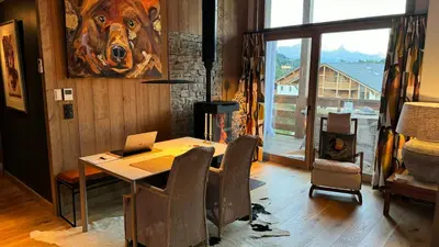 a dining room with a table with a laptop on it at Luxury Penthouse With Mont Blanc Views In Megève in Megève