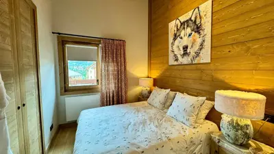 a bedroom with a bed and a picture on the wall at Luxury Penthouse With Mont Blanc Views In Megève in Megève