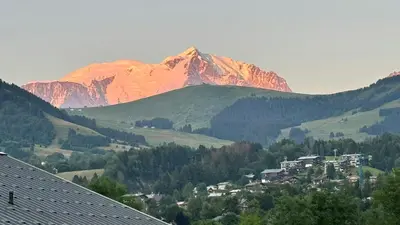 a mountain in the distance with a town in front at Luxury Penthouse With Mont Blanc Views In Megève in Megève