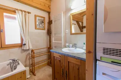 a bathroom with a sink and a toilet and a mirror at Chalet des Cimes in Samoëns