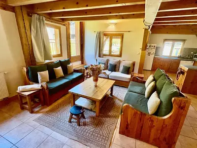 a living room with couches and a table at Chalet des Cimes in Samoëns