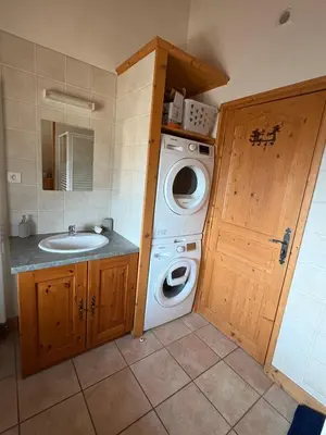 a bathroom with a washing machine and a sink at Chalet des Cimes in Samoëns