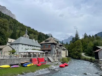 a group of kayaks sitting on the grass near a river at Chalet des Cimes in Samoëns