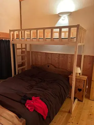 a bedroom with a bunk bed with a red shirt on it at Chalet des Cimes in Samoëns