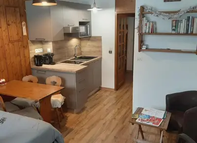 a small kitchen with a sink and a table at Grand Studio 25 m2, lumineux, central, vue Mont-Blanc in Chamonix-Mont-Blanc