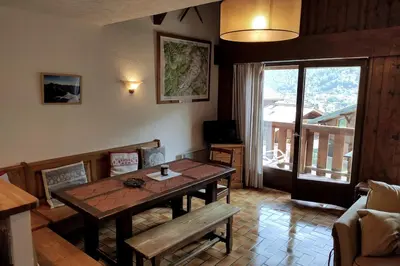 a living room with a wooden table and a window at Duplex Saint Gervais in Saint-Gervais-les-Bains