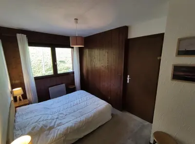 a bedroom with a white bed and a window at Duplex Saint Gervais in Saint-Gervais-les-Bains