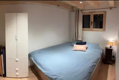 a bedroom with a blue bed and a cabinet at Face au MtBlanc avec jardin in Les Houches