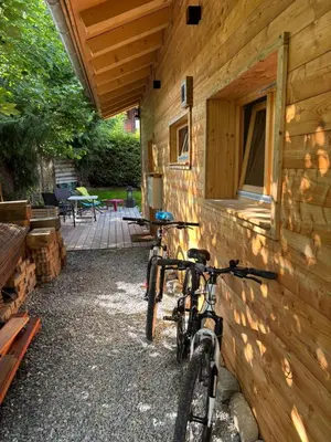 two bikes parked against the side of a log building at Face au MtBlanc avec jardin in Les Houches