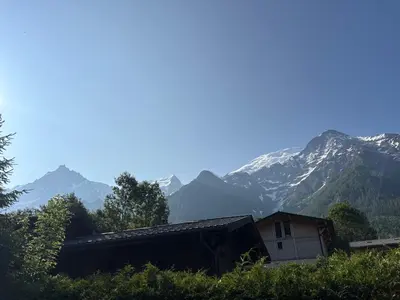a house on a hill with mountains in the background at Face au MtBlanc avec jardin in Les Houches