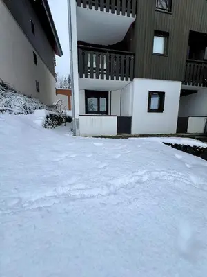 a snow covered yard in front of a building at Le LODGE Les Esserts 1100 Morillon in Morillon