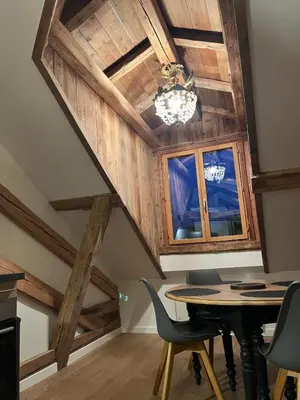 a dining room with wooden ceilings and a table and chairs at Ambiance alpine in Sallanches