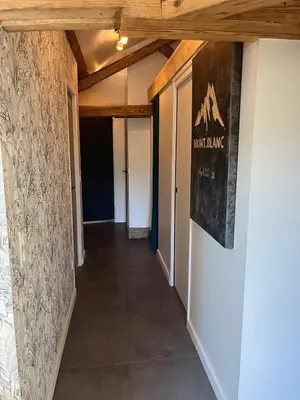 a hallway with a poster on the wall and a hallwayngthngthngthngthngth at Ambiance alpine in Sallanches