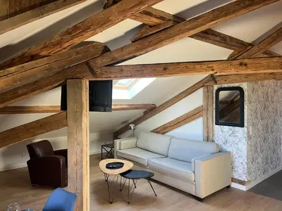 a living room with wooden ceilings and a white couch at Ambiance alpine in Sallanches