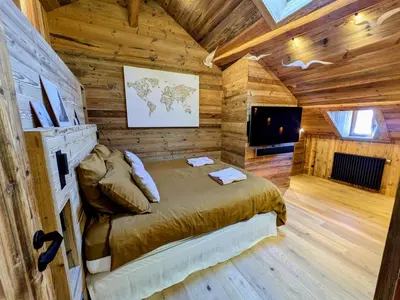 a bedroom with a bed in a wooden cabin at Appartement Nuage, Luxe, centre village Megève in Megève