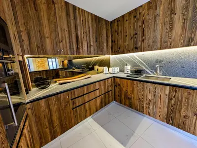 a kitchen with wooden cabinets and a sink at Appartement Nuage, Luxe, centre village Megève in Megève