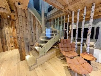 a spiral staircase in a room with wooden walls at Appartement Nuage, Luxe, centre village Megève in Megève