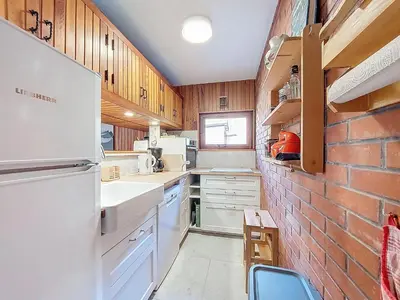 a kitchen with white appliances and a brick wall at Apartment Résidence Les Tines by Interhome in Chamonix-Mont-Blanc