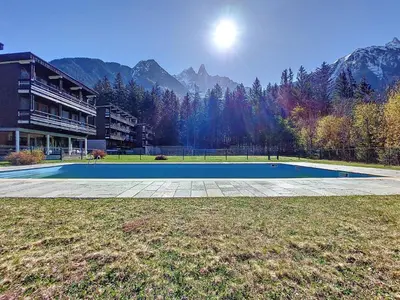 a tennis court in a field with mountains in the background at Apartment Résidence Les Tines by Interhome in Chamonix-Mont-Blanc