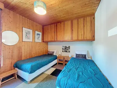 two beds in a room with wooden walls at Apartment Résidence Les Tines by Interhome in Chamonix-Mont-Blanc