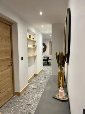 a hallway with a table and a vase with a plant at Huxa Appt Megève Centre in Megève