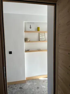 a room with white walls and a door with shelves at Huxa Appt Megève Centre in Megève