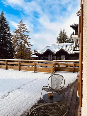 a bench sitting on a deck in the snow at Huxa Appt Megève Centre in Megève