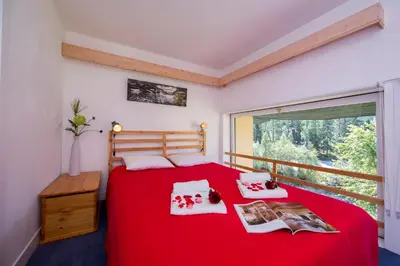 a living room with a red couch and a table at Résidence Grand Roc - Campanules 112 - Happy Rentals in Chamonix-Mont-Blanc