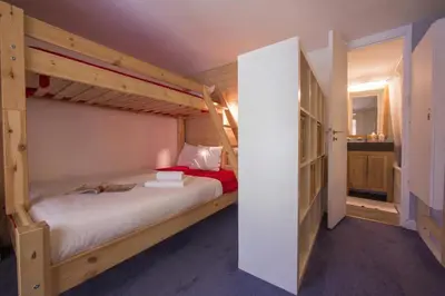 a kitchen with white cabinets and a wooden table at Résidence Grand Roc - Campanules 112 - Happy Rentals in Chamonix-Mont-Blanc