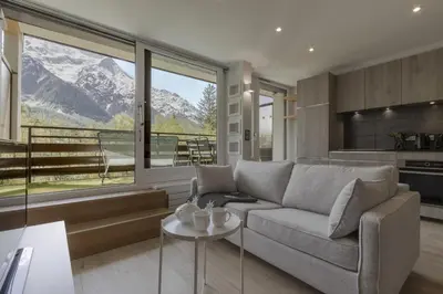 a living room with a couch and a large window at Cristal des Glaces 3 - Proche lac - Vues in Chamonix-Mont-Blanc