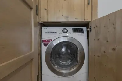 a washer and dryer in a wooden cabinet at Cristal des Glaces 3 - Proche lac - Vues in Chamonix-Mont-Blanc