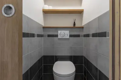 a bathroom with a white toilet and black tiles at Cristal des Glaces 3 - Proche lac - Vues in Chamonix-Mont-Blanc