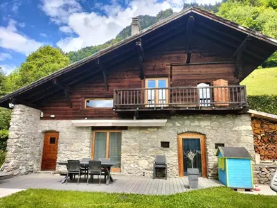 a log house with a deck and a patio at Chalet Peppa in Sallanches